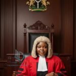 Judge wearing red judicial robe during serious court session.